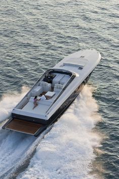 a woman is sitting on the back of a motor boat in the middle of the water