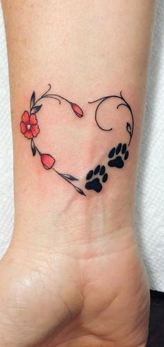 a heart shaped tattoo with paw prints and flowers on the side of the ankle area