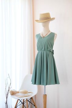 a mannequin wearing a green dress and hat