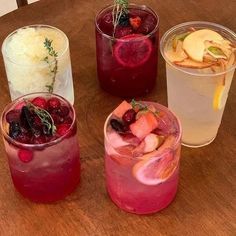 three glasses filled with different types of drinks on top of a wooden table next to each other