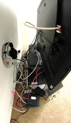 wires are tangled up and plugged into the back of a television