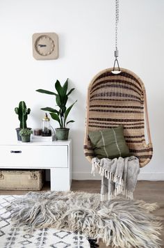 a room with a chair, rug and potted plants