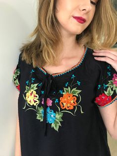 Beautiful Pong multi colored embroidery and surtache swing top multi colored on black tie neck short sleeve or 3/4 sly turquoise /orange trim throughout plus size Black Embroidered Summer Blouse, Fitted Short Sleeve Peasant Top For Vacation, Spring Short Sleeve Blouse With Boho Collar, Spring Boho Collar Short Sleeve Tops, Summer Festival Peasant Top With Embroidered Hem, Black Embroidered Top For Summer Festival, Bohemian Black Tops With Embroidered Neckline, Floral Embroidered Peasant Top For Summer, Summer Floral Embroidery Peasant Top Relaxed Fit