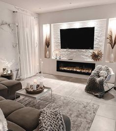 a living room filled with furniture and a flat screen tv mounted on the wall above a fireplace