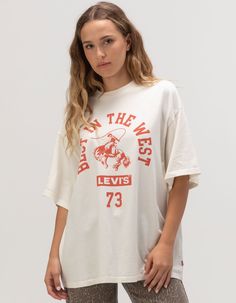 Levi's Best In The West Premium Tee. Large Graphic Screened On Front. Ribbed Crew Neckline. Short Sleeve. Oversized Fit. 100% Cotton. Machine Wash. Imported. Model Is Wearing A Size Small. Model Measurements:height: 5'9" Bust: 32"waist: 25"hips: 35" Oversized Logo Print Tops, Oversized Sporty Top With Front Print, Oversized White Top With Front Print, White Oversized Top With Front Print, Wwe T Shirts, Flannel Sweatshirt, Cropped Graphic Tees, Graphic Trends, Graphic Tees For Women