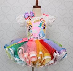 This set is perfect for your Princess Event! Set includes a 4 layer Multi color tutu trimmed in glitter and satin ribbon,and a custom tee. HAIRBOW IS INCLUDED FOR A LIMITED TIME ONLY! Checkout our Other tutu sets in our shop under the tutu set section,if you dont see what you are looking for,contact us for a custom! WE DO NOT EXCEED PAST SIZE 6 This is our Deluxe version, use search term "princess" to see other versions If you are unsure of sizing please scroll to the last photos for our size charts, or visit our size charts here--> https://pinktoesnhairbows.com/pages/size-chart All sales are FINAL, Ship dates can be found directly on the listing, please view our policies in detail here---> https://pinktoesnhairbows.com/pages/policies-terms-conditions *****Due to Many Request,Bows are No l Princess Style Birthday Tutu Dress, Princess Style Birthday Tutu Dress With Tulle Skirt, Overalls Boys, Tutu Dress Costumes, Girls Overalls, Princess Tutu, Custom Tee, Birthday Tutu, Princess Outfits