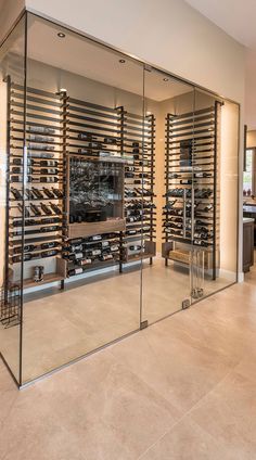 a large wine cellar with glass walls in the middle of an open floor plan area