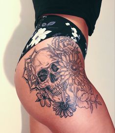 a woman's thigh with a skull and flowers on it