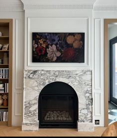 a white fireplace with flowers on the mantle