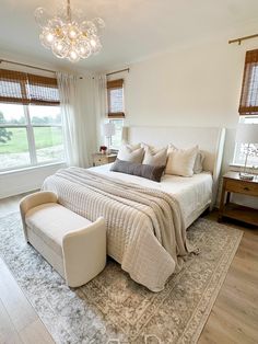 a large bed sitting in the middle of a bedroom next to a window with curtains