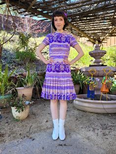 "Groovy! A psychedelic drop waist scooter dress that is beige/nude with a purple paisley print. Almost a mock neck, but it actually it's a snug v neck. The dress zips up the back and has two hook and eye closures at the back of the neck. It has short sleeves, and darts at the bust. The cut of the dress is straight, meaning it does not come in at the waist, for that classic 60s silhouette. The drop waist starts at the base of the bum and the dress is pleated below that. The dress is knee length and not stretchy, so do pay attention to the measurements below. Works best on a size XS, or someone with slim hips who has some wiggle room to these measurements. Label reads \"made expressly for Nicole San Francisco in the British Crown Colony Hong Kong\" and is made of 100% polyester. Excellent co 60s Silhouette, Retro Cocktail Dress, Scooter Dress, Mod Scooter, Light Blue Knit, Slim Hips, Metallic Mini Dresses, Purple Paisley, Brocade Dresses