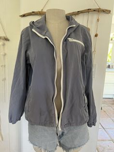 John Galt, Brandy Melville Cotton Front Zip Jacket, one size. 100% Cotton.  **Please note front zipper is broken and has no pull. Sold as is. Please look at pictures for exact condition. Jacket has a hoodie and has long sleeves with elastic cuffs. Front zipper is white and there is also a zippered pocket on front left chest.  The jacket can be cinched at bottom hemline. Super soft sueded chambray cotton with cotton lining in same color. Measurement from armpit to armpit is 21" across, sleeve len Blue Zipper Windbreaker For Fall, Blue Windbreaker With Zipper Closure For Fall, Blue Windbreaker With Zipper For Fall, Blue Zipper Closure Windbreaker For Fall, Casual Blue Windbreaker With Zipper, Casual Blue Windbreaker With Zipper Closure, Blue Cotton Outerwear With Zipper Closure, Brandy Melville Christy Hoodie, Brandy Melville Arden Hoodie