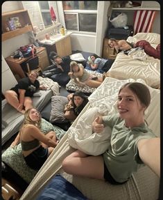 a group of young women laying on top of a bed in a bedroom next to each other