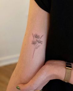 a woman's arm with a flower tattoo on the left side of her arm