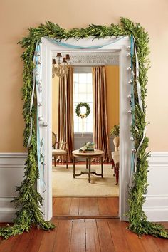 an open door to a living room decorated with greenery and wreaths on the wall