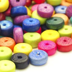 many different colored wooden beads on a white surface