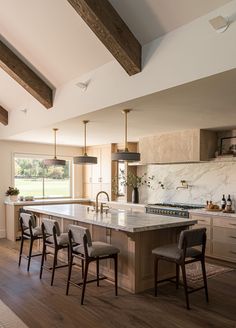 a large kitchen with an island in the middle and lots of counter space on one side