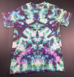 adult medium trip style green and purple tie-dye t-shirt. Summer Festival Green T-shirt, Casual Green Festival T-shirt, Green Crew Neck T-shirt For Festival, Green Short Sleeve T-shirt For Festivals, Hand Dyed Hippie Short Sleeve T-shirt, Bohemian Tie Dye T-shirt For Festivals, Hand Dyed Purple Short Sleeve T-shirt, Bohemian Tie Dye Short Sleeve T-shirt, Hippie Tie Dye T-shirt For Festivals