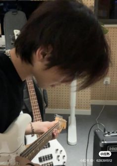 a young man is playing an electric guitar