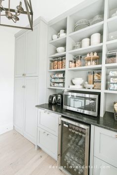 a kitchen with white cabinets and open shelves