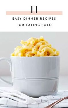 a white bowl filled with macaroni and cheese sitting on top of a table