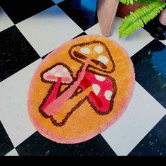 a black and white checkered floor with a pink rug on it that has an image of mushrooms