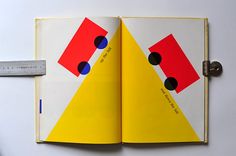 an open book with geometric shapes on the pages and a ruler in front of it