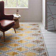 a chair sitting in front of a window on top of a rug