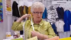 an older woman is holding up some shopping bags