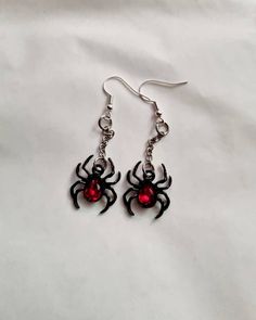 Gorgeous black spider earrings 🖤 Black spider with red crystal back hanging on a little silver chain 🖤 The spiders are approx 15mm x 10mm (1.5cmx1cm) and the chain is 15mm long 🖤 Hanging on silver plated lead and nickel free earring hooks 🖤 Perfect gothic spider earrings to add to your collection 🖤 Spooky Red Halloween Jewelry, Spooky Black Nickel-free Jewelry, Red Metal Halloween Earrings, Alternative Fits, Creepy Earrings, Gothic Spider, Grunge Earrings, Earrings Gothic, Spider Earrings