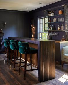 a bar with stools in front of it and shelves on the wall behind it