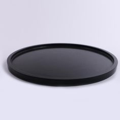 a black plate sitting on top of a white table