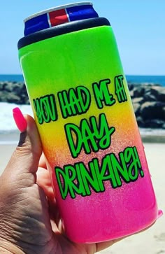 a person holding up a pink and green flask with the words you had me at day drinking on it