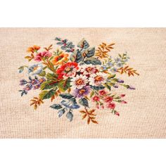 a cross stitch pattern with flowers and leaves on the bottom half of it, in pastel colors