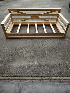 a wooden bed frame sitting on the ground