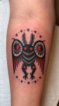 a black and red owl tattoo on the left leg, with stars around its eyes