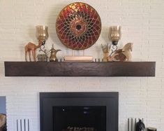 the fireplace is decorated with candles and other decorative items, including an art piece on top