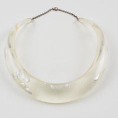 This is part of Chairish’s Costume Jewelry assortment.  An elegant Italian artisan designer studio collar choker necklace.  Lucite or resin rigid bib shape in translucent clear color ornate with silver flakes inclusions in an organic abstract free-form design. Silvered metal chain to adjust the length. No visible maker's mark. Measurements: The inner circumference is 16.57 in (42 cm) - the front height is 1 in (2.6 cm) - the opening is 3.38 in (8.5 cm) - the necklace will fit an average 14.57 in Luxury Clear Necklaces, Elegant Clear Resin Jewelry, Elegant Clear Metal Necklace, Luxury Handmade Clear Necklace, Elegant White Resin Necklace, Adjustable Elegant Resin Necklace, Formal Clear Lucite Jewelry, Luxury Clear Lucite Jewelry, Modern White Lucite Jewelry