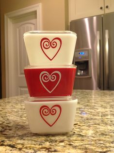 three bowls stacked on top of each other with hearts painted on them