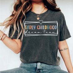 a woman wearing a t - shirt with the words early childhood written in white on it