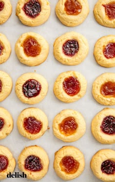 a person placing jam on top of cookies