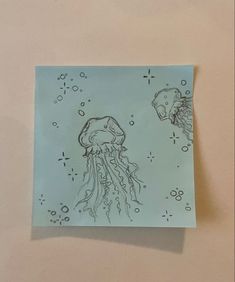 a piece of paper with a drawing of two jellyfish on it's side