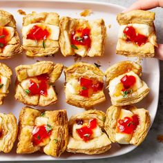 a white platter filled with pastry covered in jelly and other confection toppings