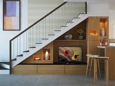 a living room filled with furniture and a flat screen tv sitting on top of a wooden shelf