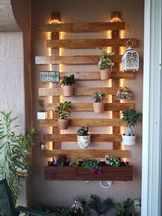 a wall mounted planter filled with potted plants on top of wooden pallets