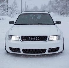 a white car is parked in the snow