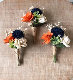 three bouquets of flowers are arranged on a table