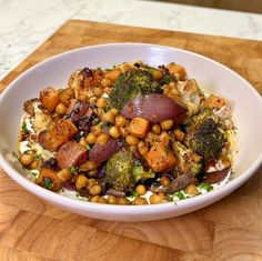 a white bowl filled with food on top of a wooden table