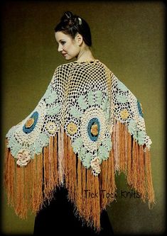 a woman wearing a crocheted shawl with flowers on the top and fringe