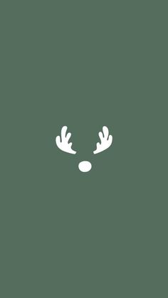 an animal's face is shown in white on a dark green background, with two large antlers sticking out of it